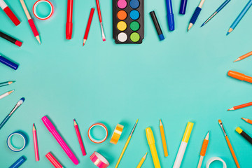 School items as a frame on blue background. Trendy colors, flat lay style. Back to school concept.