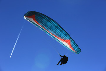 paraglide pilot in blue sky