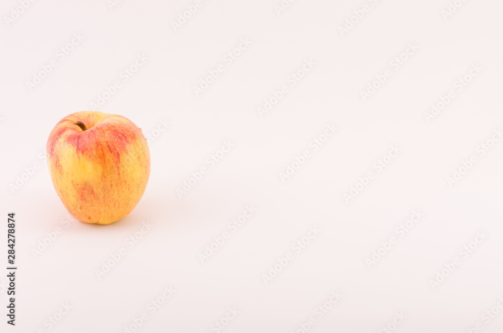 Wall mural yellow red apple fruit on a white surface - natural nutrition