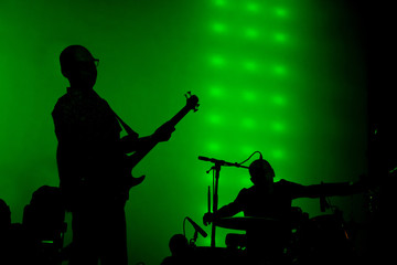 Rock musicians at a concert, guitarist and drummer, silhouettes of musicians, live show