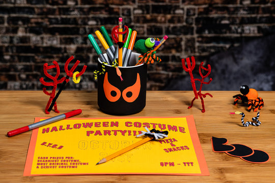 Doing crafts and Making a Party Sign for Halloween.  Several Halloween Craft decorations are also in the shot.  Negative Space for Copywriting.