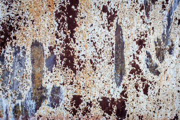 Old metal rusted wall partly covered with peeling paint. Grunge texture and background. Close-up