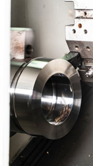 The CNC lathe machine chucking the metal shaft.The turning machine cutting forming cutting the metal shaft