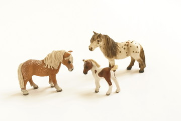 Toy horses family on white background 