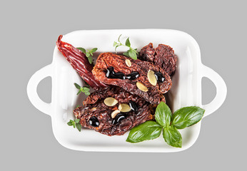 Decoration with dried tomatoes on a gray background.