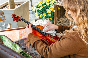 Girl takes violin from case and rubs for playing