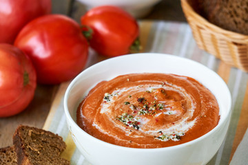 Soup puree with baked tomatoes in a white bowl 
