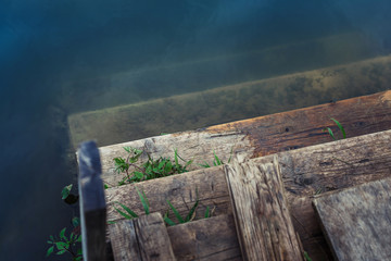 Old wooden staircase in the water. Romantic relaxed mood.