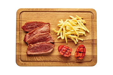 Medium rare sirloin steak with chips and grilled tomatoes isolated on white background. Classic European lunch studio flat lay shot. Top view, directly above.