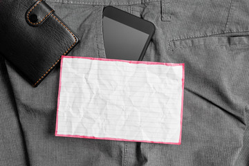 Smartphone device inside trousers front pocket with wallet and note paper