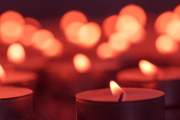 Burning candle on blurred background
