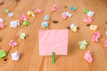 Colored crumpled papers empty reminder wooden floor background clothespin