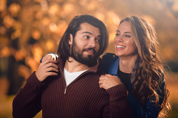 Couple in autumn season colored park enjoying outdoors.