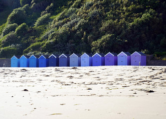 Reihe Strandhütten vor grünem Hang