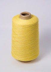 Green bobbin of yarn on a white background.Textile reel on isolated white background.