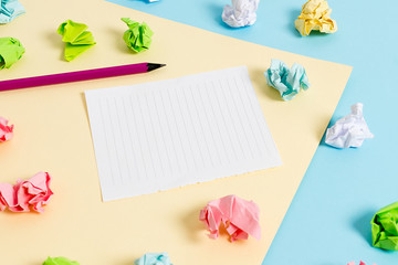Colored crumpled papers empty reminder blue yellow background clothespin