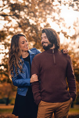 Fototapeta premium Couple in autumn season colored park enjoying outdoors.