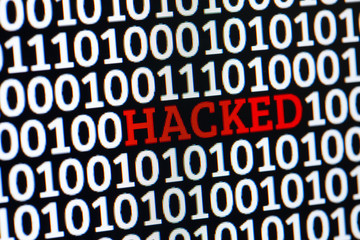 Red inscription HACKED in binary code of ones and zeros. Cyber attack electronic devices.
