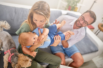 Parents playing with a baby at home.