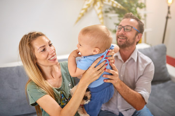 Parents playing with a baby at home.