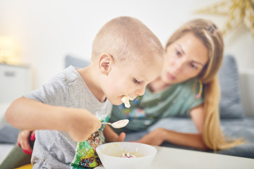 Obraz na płótnie Canvas Son making mess while eating food.