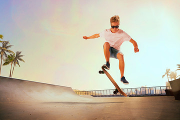 Skateboarder is performing tricks in skatepark on sunset. © Artur Didyk