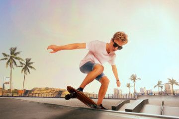Skateboarder is performing tricks in skatepark on sunset.