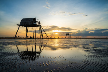 Sunrise on oyster raising field with watchtowers in Dong Chau beach, Thai Binh, Vietnam