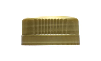 Golden new plastic bottle cap isolated on white, side view, macro