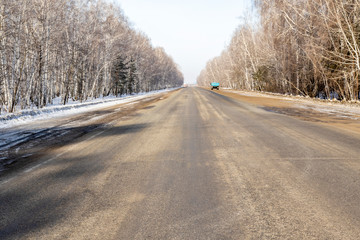 Obraz na płótnie Canvas Road asphalt to the sky through the forest, winter landscape.