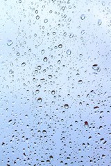 Raindrops on the glass, dark blue sky background outside the window.