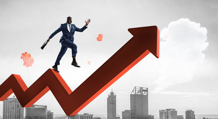 Black businessman climbing red zigzag increasing arrow