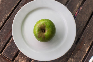 Top view of fresh green apple on a plate isolated