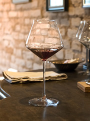 A glass of red vintage wine stands on wooden chest