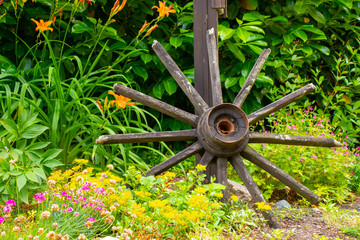 kaputtes Wagenrad aus holz ohne Rad im gr&uuml;nen