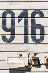 Black numbers on wooden fence background.