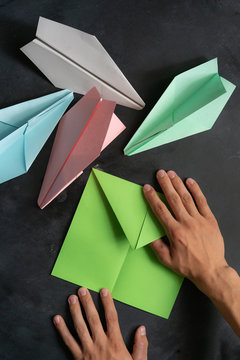 person hands making a origami color paper plane