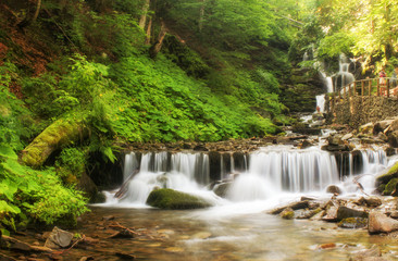 Landscape of waterfall Shypit in the Ukrainian Carpathian Mountains on the long exposure. Landscape panorama. Noises and large grain - stylization under the film. Soft focus