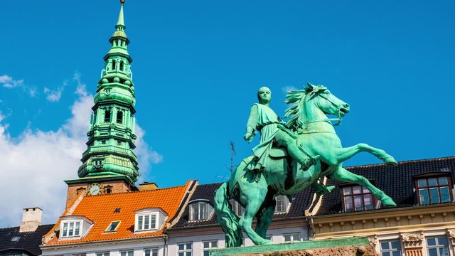 Copenhagen, Denmark. Vie wof Bishop Absalon statue and Nikolaj Copenhagen Contemporary Art Center in Copenhagen, Denmark. Time-lapse during a sunny summer day with clouds in the blue sky, zoom in