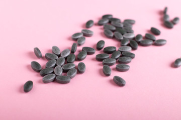 Spirulina tablets, chlorophyll on a pink background