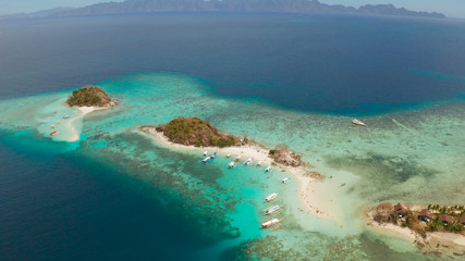 Fototapeta na wymiar aerial seascape bay with tropical island and sand beach, turquoise water and coral reef. Bulog Dos, Philippines, Palawan. tourist boats on coast tropical island.