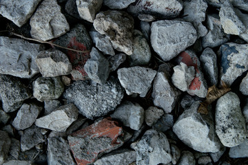 Gray and red stones and gravel lie in one heap