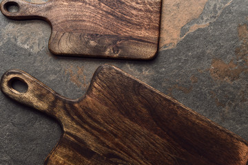 top view of brown wooden chopping boards on weathered grey background