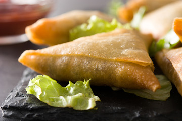 Samsa or samosas with meat and vegetables on black background. Traditional Indian food. Close up