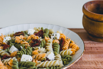 A pasta plate with fresh cheese and dried tomato