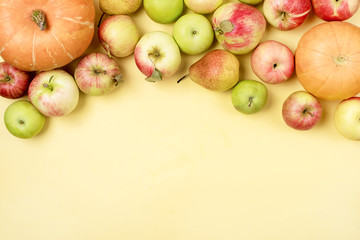 Thanksgiving Background Apples Pumpkins on Yellow Background Copy Space For Text Horizontal Halloween Thanksgiving day or Seasonal Fall Background Top View
