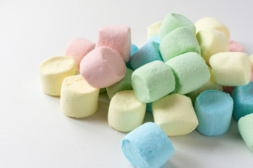 Colored marshmallows on a white background. A closeup of colored marshmallows.