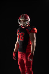 American football player in helmet standing against black background © wavebreak3