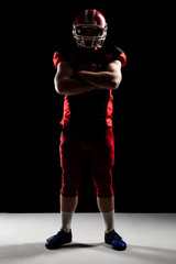 American football player in helmet standing with arms crossed © wavebreak3