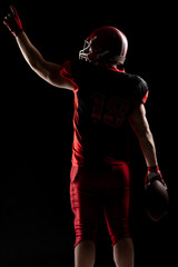 Fototapeta na wymiar American football player in helmet pointing upwards